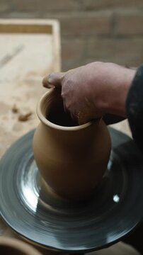 Hands of a potter, creating an earthen jar on the circle. Woman makes hand made ceramics from clay
