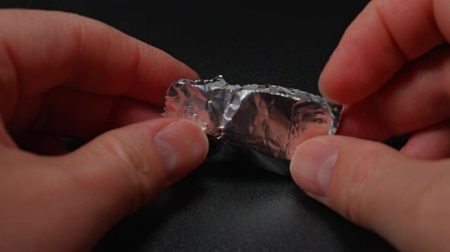 Fentanyl or crystal meth is widely used stimulant in current drug trend. Methamphetamine mixed with fentanyl as crystals in foil. Illicit substance in foil bag for transportation and sale.