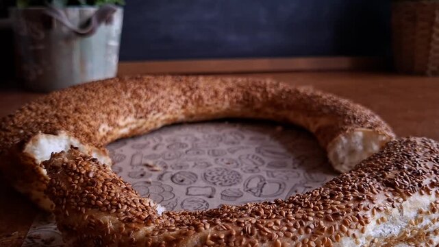Hands Breaking Traditional Turkish Simit with Sesame Seeds