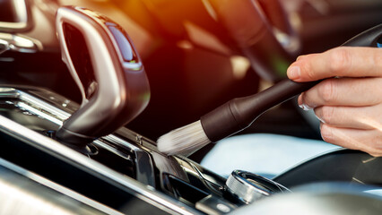 Naklejka premium Hand cleans car interior with soft brush