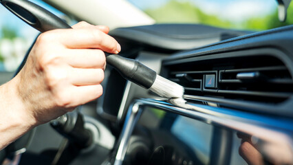 Naklejka premium Hand cleans dashboard with soft brush