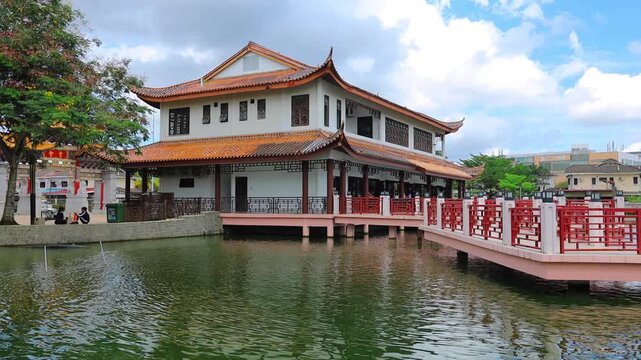 Traditional Chinese-style temple building reflected in the water along the waterfront of Kuching, Sarawak, Malaysia