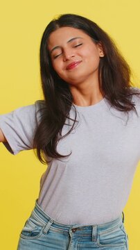 Tired exhausted Indian young woman yawning, sleepy inattentive feeling somnolent lazy bored gaping suffering from lack of sleep, falling asleep. Arabian Hindu girl isolated on yellow studio background