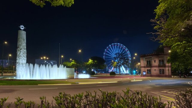 Christmas timelapse of the Juan Sebasti&aacute;n Elcano Monument in Seville, with festive lights and a Ferris wheel in the background.