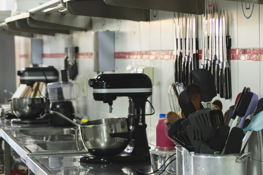 Professional kitchen featuring various appliances and tools, including mixers and knives, ready for preparing food and embracing innovative culinary techniques