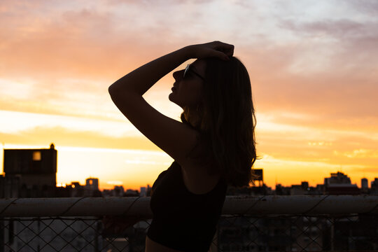 Teenage girl enjoying peaceful sunset view over city