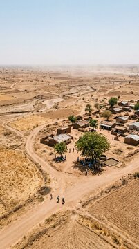 Aerial View of a Remote Rural Village in an Arid African Landscape with Small Houses and Dirt Roads