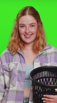 Redhead woman taking off throwing out glasses into bin after medical vision laser treatment therapy surgery looking smiling at camera, heal, cure. Pretty girl isolated on green chroma key background