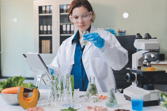 Scientists in lab coats work with plants in a modern lab, focusing on research and experimentation under bright, sterile conditions.