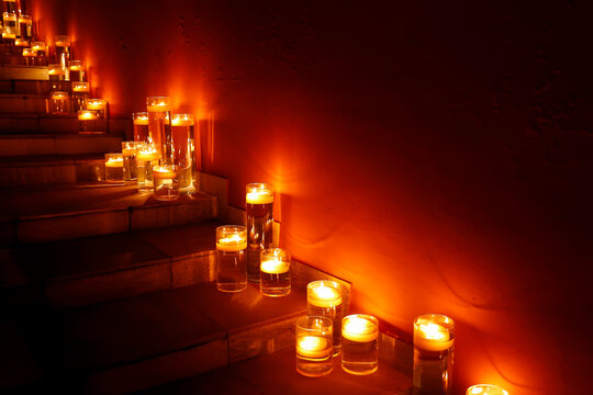 Warm glowing floating candles in glass vases on stairs for romantic atmosphere