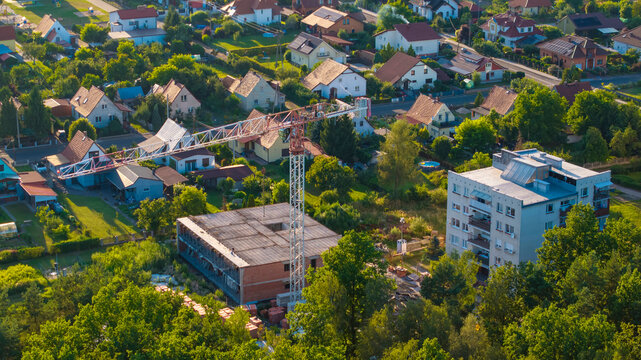 Single Construction Crane Building a New Multi-Family Home in a Small Town, Suburban Development and Real Estate Market.