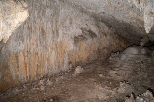 Natural limestone cave interior with stalactites and rock formations, underground cavern landscape for geology, adventure and exploration concepts