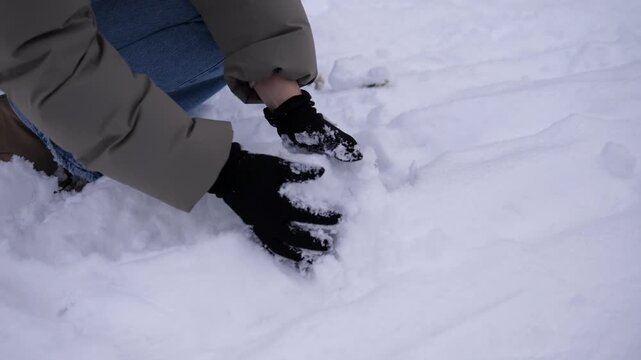 Close-up of hands making snowballs from fresh fallen snow outdoors in winter. Cozy seasonal activity and winter recreation concept