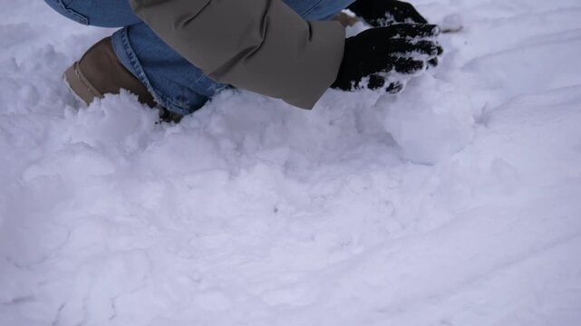 Close-up of hands making snowballs from fresh fallen snow outdoors in winter. Cozy seasonal activity and winter recreation concept