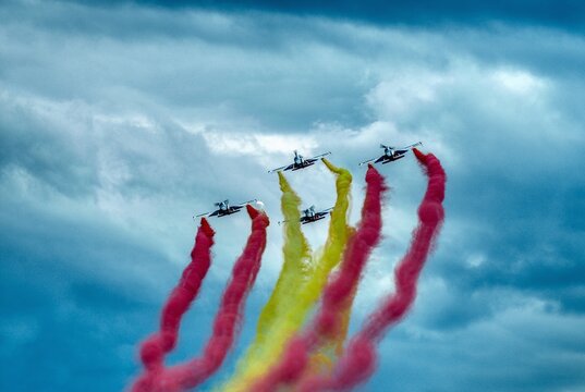 The Eagle Patrol of the Spanish Air Force drawing the flag of Spain over the bay of Gijon on the occasion of DIFAS 2024 in Asturias.