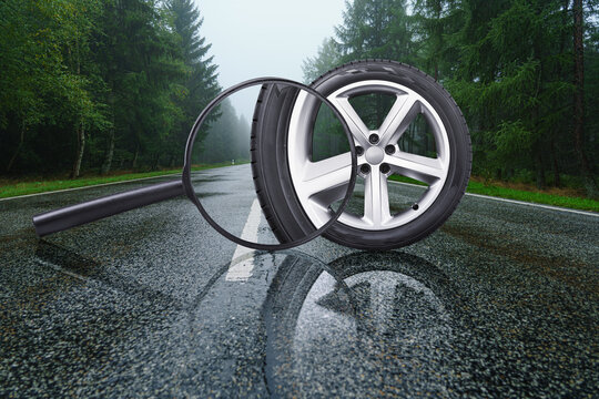 car tire with rim being examined with a magnifying glass. Driving safely on wet asphalt.