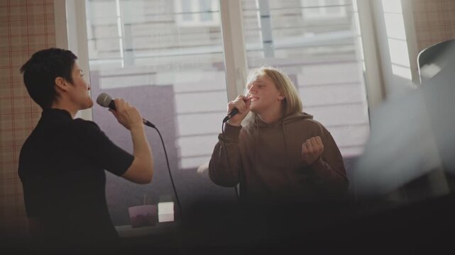 Vocalists collaborate with instructor. Duet singers refine harmony with coach during interactive session. Two vocalists work on harmony and emotional expression with guidance and teamwork