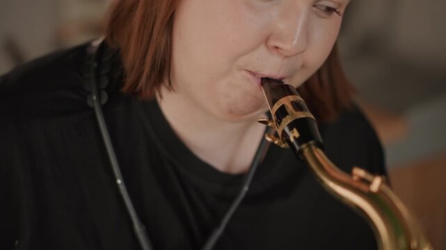 Female sax practice. Home studio session where woman meticulously practices saxophone technique. Woman concentrates deeply during her saxophone lesson conducted in personal studio setting
