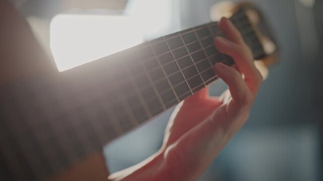 Guitar practice session. Practicing barre chords and scales under moody lighting with precision. Musician executing barre chord shapes and running scales in dimly lit studio environment