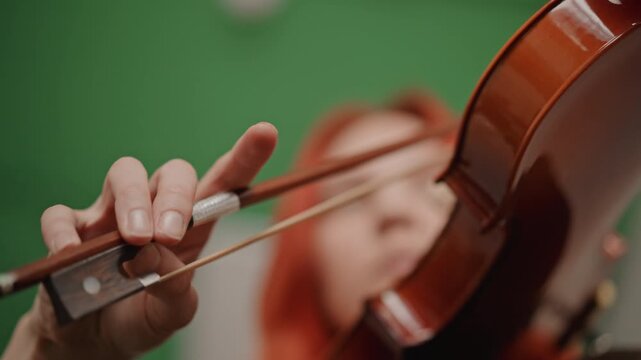 Professional studio capturing violin with motion effects and expressive playing. Advanced film studio setup recording violin performance featuring green screen visuals and dynamic motion effects