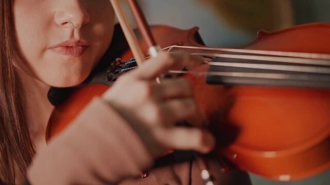 Student practicing expressive violin techniques. Close view of violin and bowing movements. Detailed depiction of student highlighting emotional and lyrical playing techniques in studio