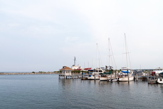 Serene marina featuring sailboats and yachts docked beside a waterfront pier with calm water at Petoskey, Michigan