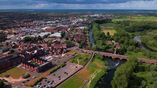 Wide aerial view of river bridge dividing urban town and countryside