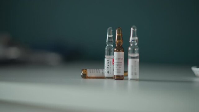 Organized pharmaceutical preparation setup. Precise grouping of medical ampoules and bottles. Methodical assembly of medication containers with labels in sterile laboratory environment