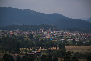 Fototapeta premium Distant panoramic view of the rural mountain town nestled in the mexican highlands.