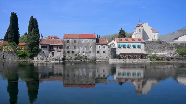 Peaceful urban scenery of Trebinje in Bosnia and Herzegovina. Reflection of historic houses in Trebi&scaron;njica river. Cityscape of Trebinje with river water reflection.
