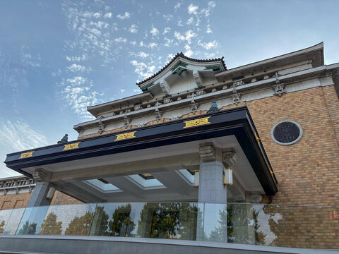 ​青空と和洋折衷の美しい建築デザインが映える「京都市京セラ美術館」の本館正面エントランス見上げる構図。歴史的建造物の重厚感と帝冠様式の意匠が特徴的な京都の観光スポットとアートの拠点。