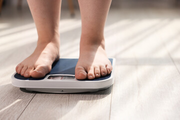 Fototapeta premium Overweight woman on scale at home, closeup. Space for text