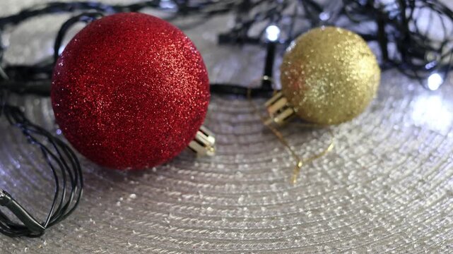 Una toma de cerca de bolas y adornos de navidad de varios colores con luces de navidad en un fondo negro