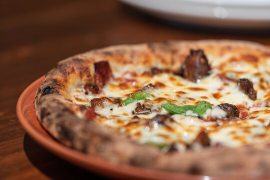 Delicious freshly baked Italian pizza served on wooden plate