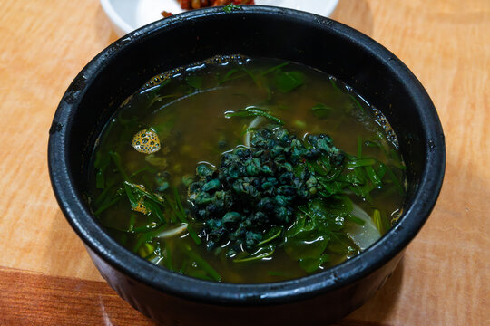 Close-up of traditional Korean marshmallow snail soup in earthenware bowl