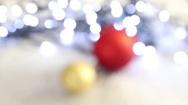 Una toma de cerca de bolas de navidad de varios colores con luces de navidad con desenfoque en un fondo negro. 