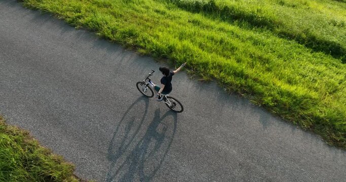 Riding bike without holding the handlebar on beautiful country road