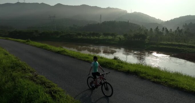 Riding bike without holding the handlebar on beautiful country road