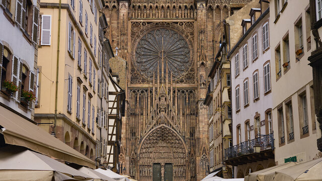 Strasbourg Cathedral's ornate Gothic facade dominating a narrow street with traditional Alsatian buildings