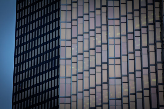 Abstract close view of skyscraper windows and office tower facades in a North American downtown, showing glass patterns, corporate architecture and a business background.