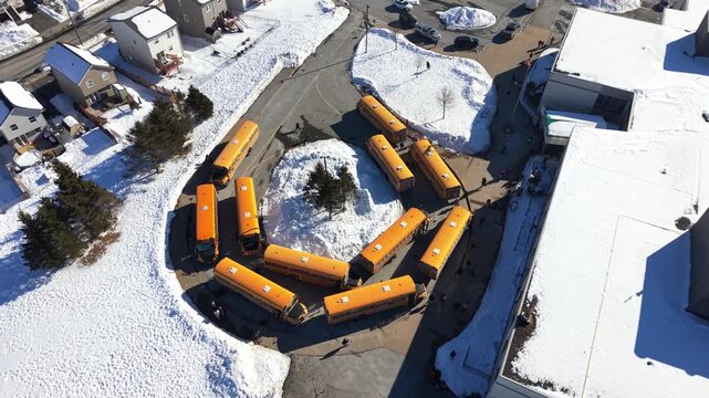 Snowy winter view of yellow school buses gathered around a school in Halifax, Nova Scotia, Canada