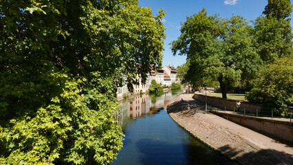 Fototapeta premium Strasbourg cityscape with buildings reflecting in the Ill River on a sunny day