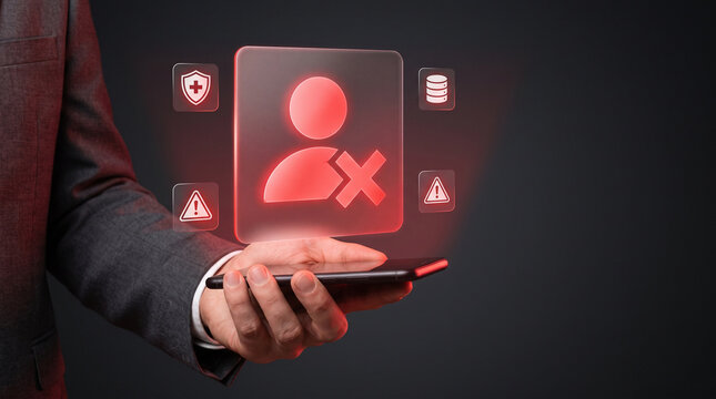 Businessman holding smartphone with glowing red user block icon for account termination data breach identity theft profile deletion and cyber security alert concept