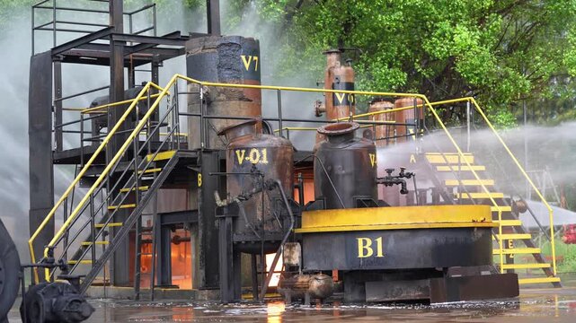 Industrial plant refinery chemical reactor fire, smoke, water spray, emergency response safety hazard, firefighters cooling steam pipes, distillation column staircase, industrial accident