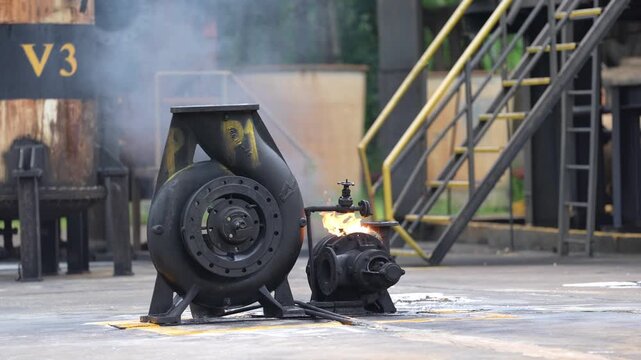 Industrial pump fire smoke factory equipment emergency hazard safety drill, burning machinery near stairway and pipeline on worksite, motor valve shutdown maintenance, safety training
