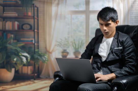Young Man Working on Laptop in Cozy Indoor Environment with Plants