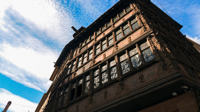 STRASBOURG, FRANCE - AUGUST 6, 2026 - Maison Kammerzell featuring ornate wood carvings and leaded glass windows under blue sky
