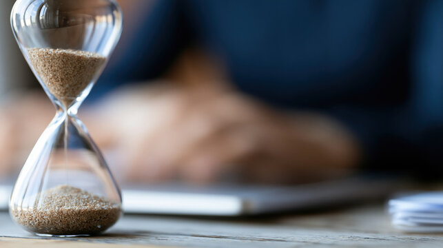 Hourglass on office desk blurred background time management business concept sand timer work space deadline focus office desk productivity