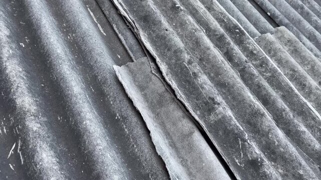 Close up of broken corrugated asbestos roof sheet with big crack