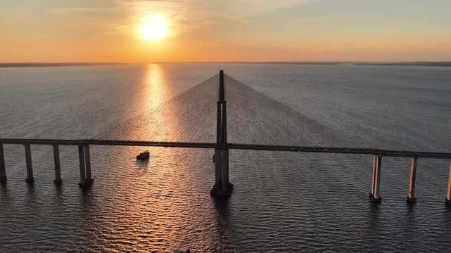Sunset Cable Stayed Bridge At Manaus In Amazonas Brazil. Sunset Bridge. Boat Sailing. Amazon Black River. Cable Stayed Bridge In Manaus In Amazonas Brazil. Beautiful Sunset Skyline. Amazon Rainforest.